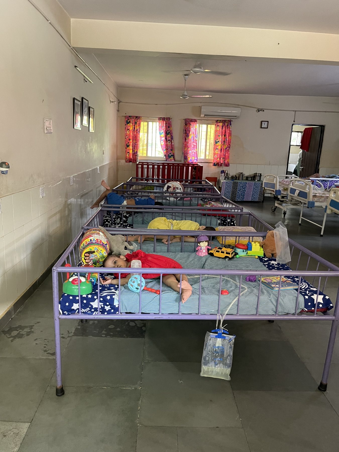 A wider Palna care room with beds, toys, and staff support areas