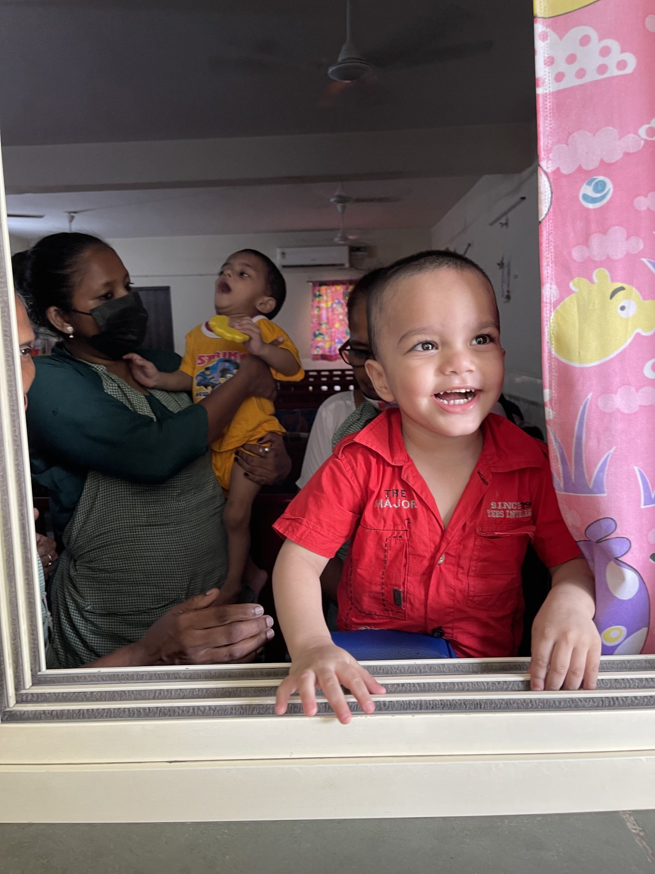 A child smiling near a window at Palna